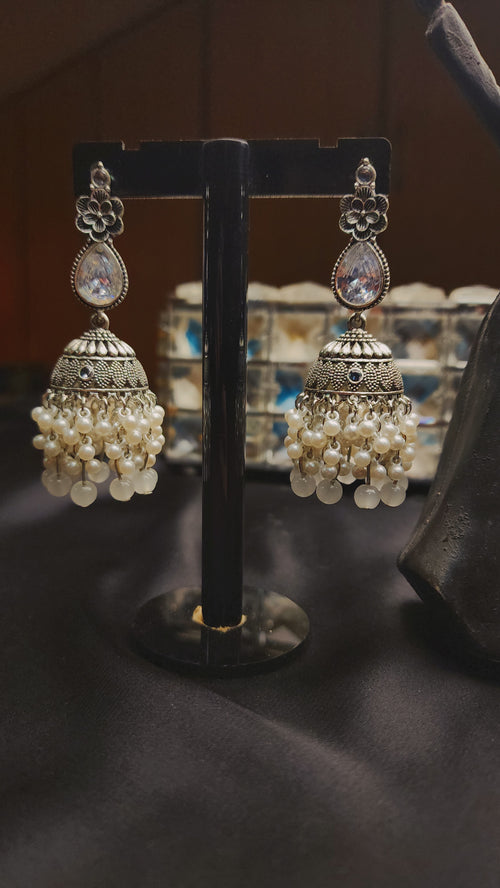 A pair of ornate, silver-toned Indian jhumka earrings 🌸🎀