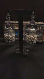 A pair of ornate, silver-toned Indian jhumka earrings 🌸🎀