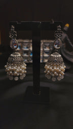 A pair of ornate, silver-toned Indian jhumka earrings 🌸🎀
