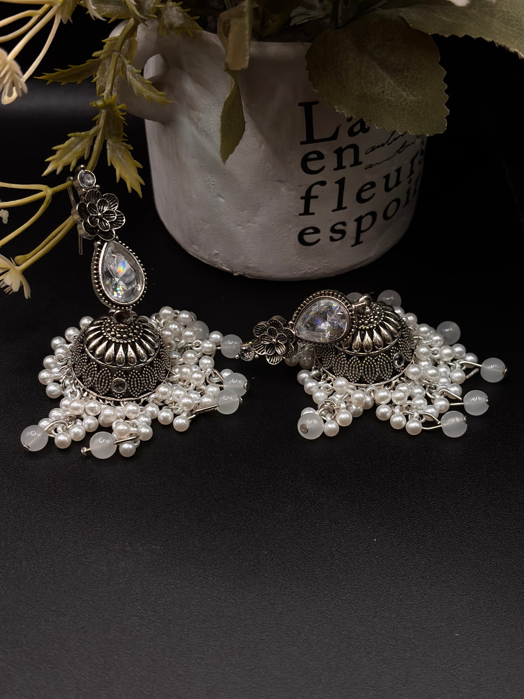 A pair of ornate, silver-toned Indian jhumka earrings 🌸🎀