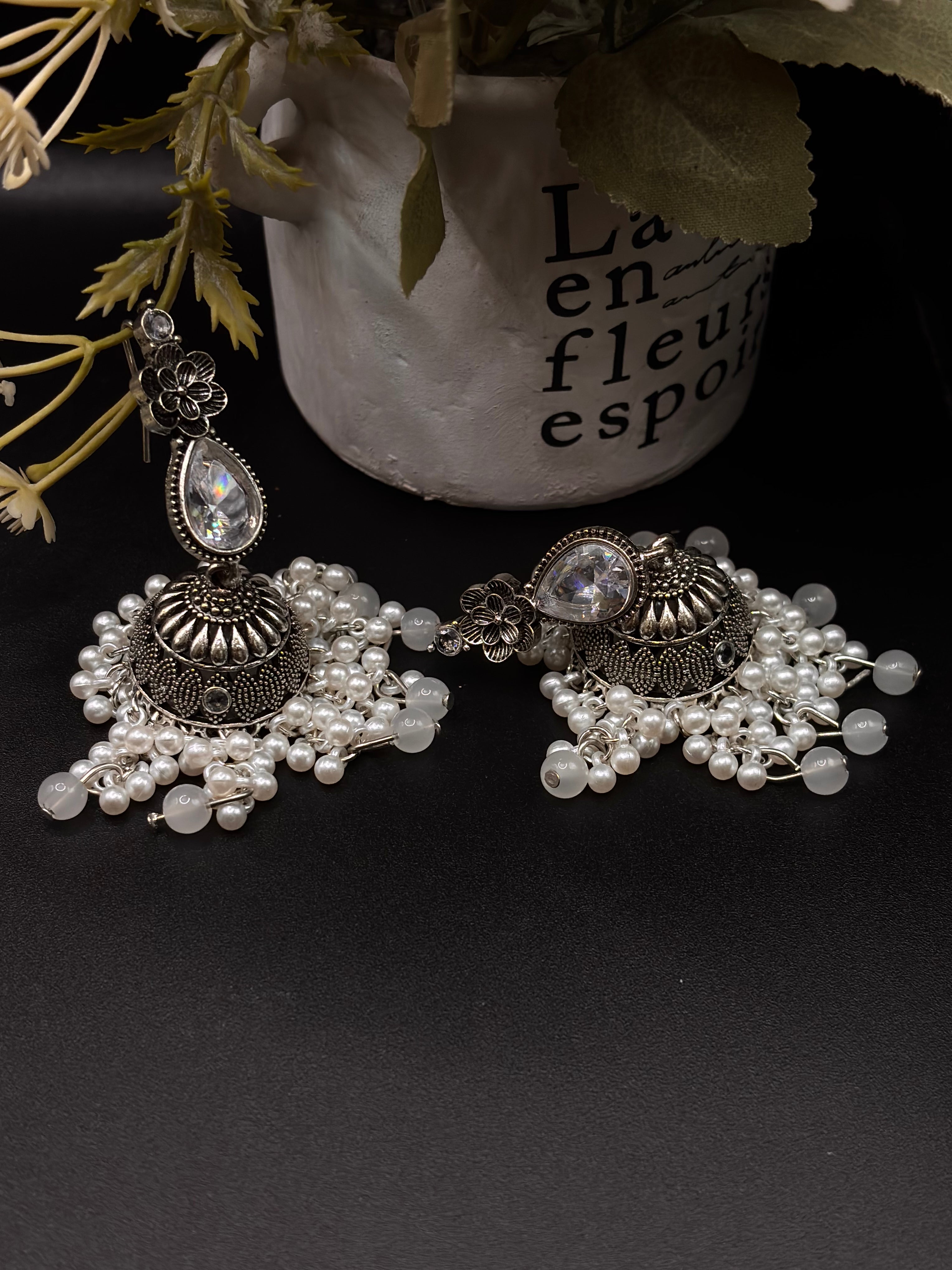 A pair of ornate, silver-toned Indian jhumka earrings 🌸🎀